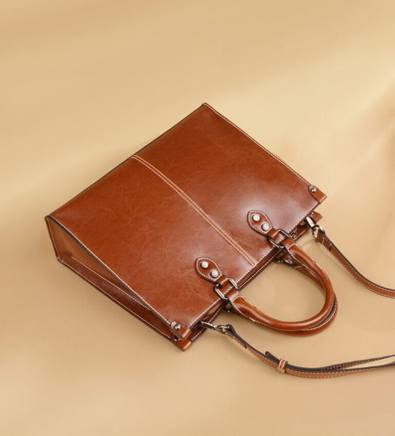 Brown leather handbag on beige background